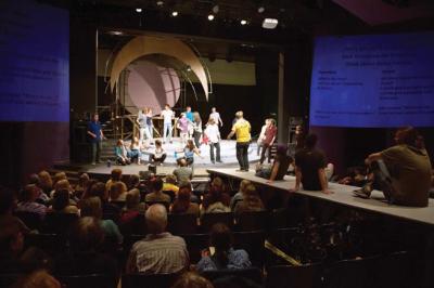 A photo from the Daily Camera showcases the projection screens employed in the performance during a rehearsal of Jesus Christ Superstar. Unfortunately, due to theater rules, it was not possible to capture a photograph of the live video feed during the actual production.